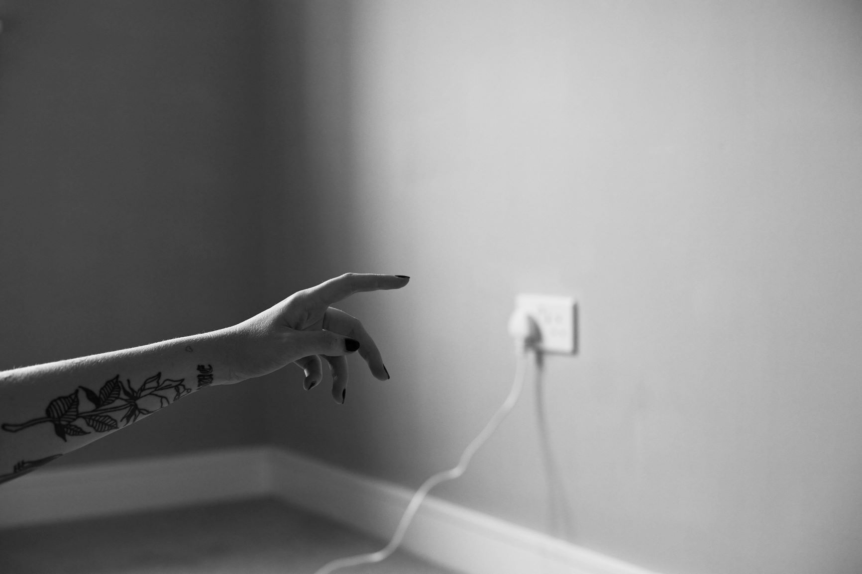 Photo portrait of arm pointing a plug socket