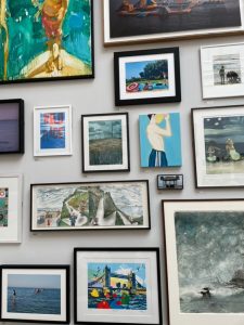 A wall with a selection of framed prints including kaths print.