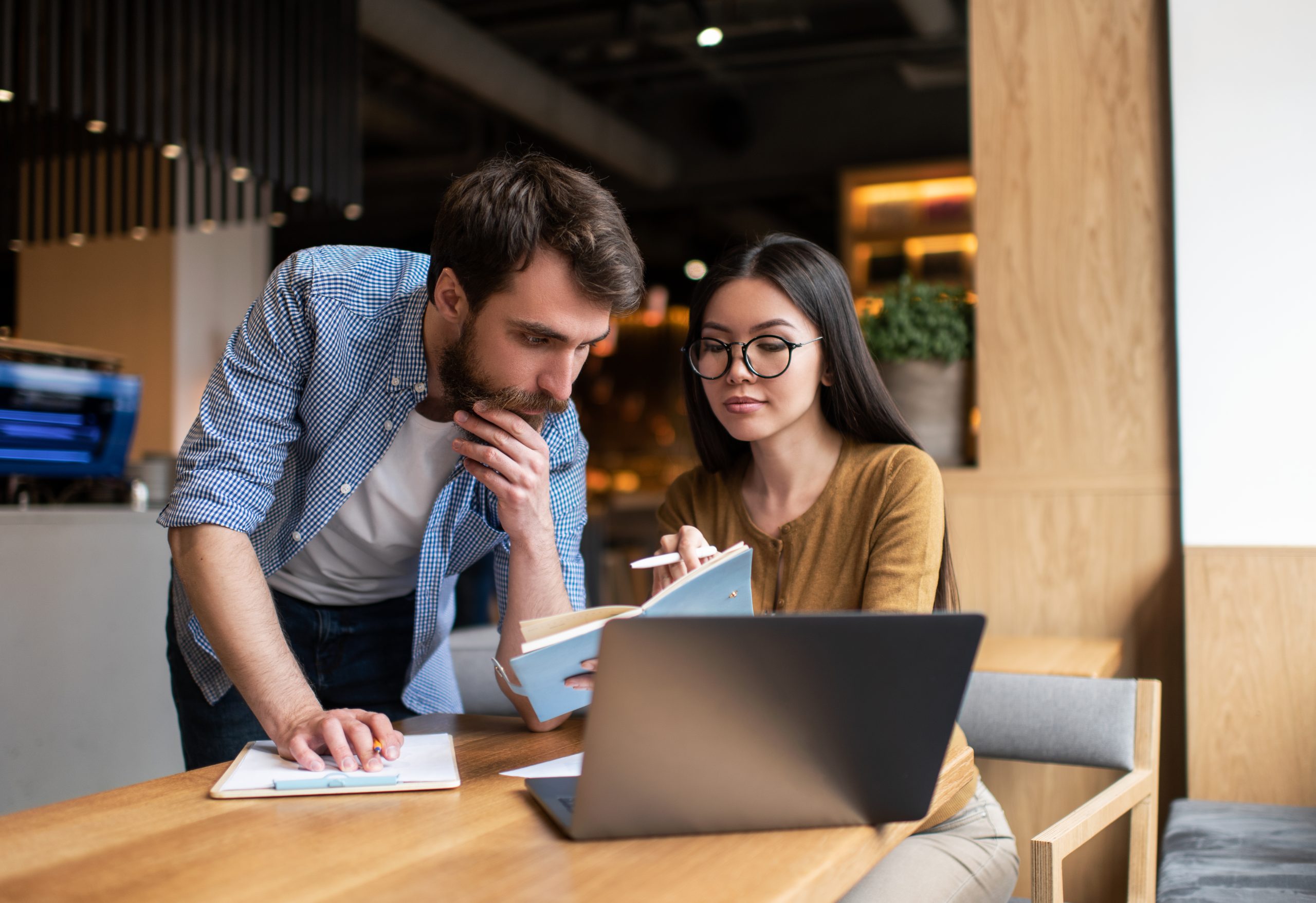 Business colleagues working startup project together, meeting, brainstorming, talking, planning strategy, looking for solution. Portrait of employer and employee sitting in office. Successful business